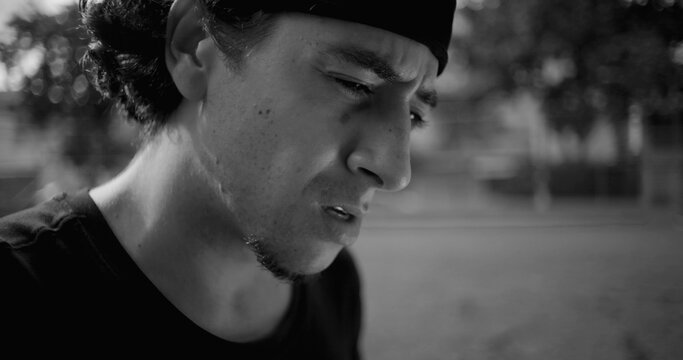 Close-up Hispanic man showing visible frustration and anger, expression filled with regret and annoyance, reflecting emotional tension and inner conflict, black and white