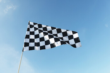 Obraz premium One checkered flag against blue sky outdoors, low angle view