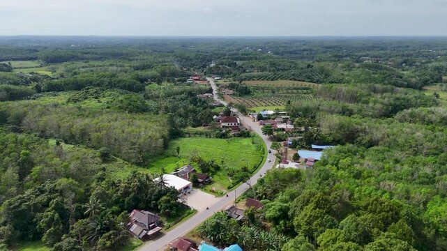 The Pelaihari Hills feature roads, local houses, farmland, and lush green natural scenery