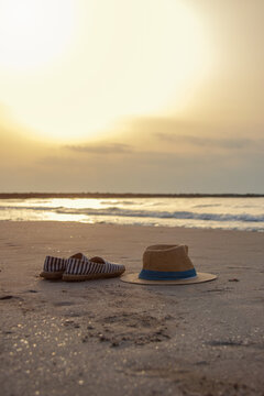 Vertical panama hat and espadrilles on golden beach