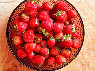 Fresh strawberries filling a glass bowl. © Marina