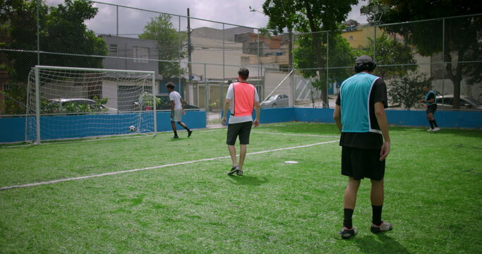 Friends playing casual soccer on neighborhood field, player kicks ball into goal scoring point, concept of teamwork, joy, and passion for community sports
