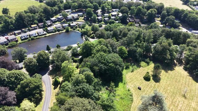 Aerial drone 4K scene showing caravans placed beside farmland greenery with warm natural tones Wales