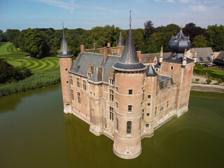 A stone castle surrounded by water and reeds on the water's edge. © rusevdmitrii