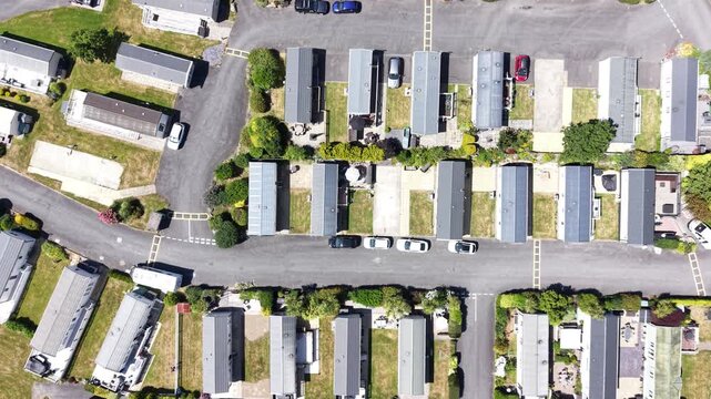 Aerial drone 4K clip showing caravans placed near meadow grass with warm daylight Wales