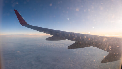 Fototapeta premium View on sunset and airplane wing from the inside