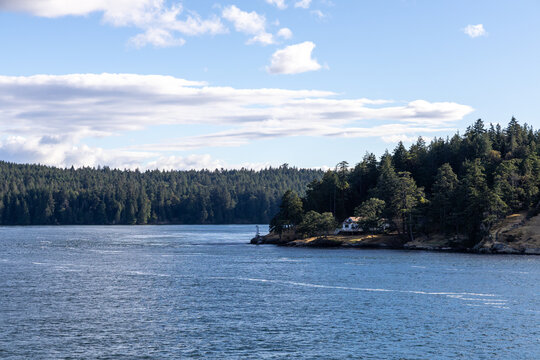 Coastal Island Home and Lighthouse Overlooking Forested Water on Galiano Island, British Columbia