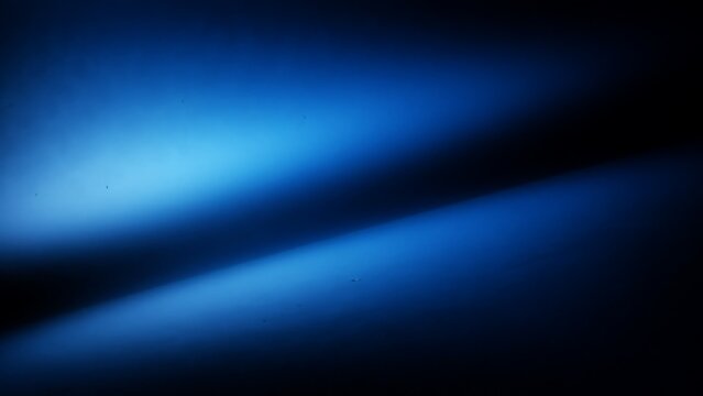 Abstract blue light beams shining in dark space  dramatic illumination