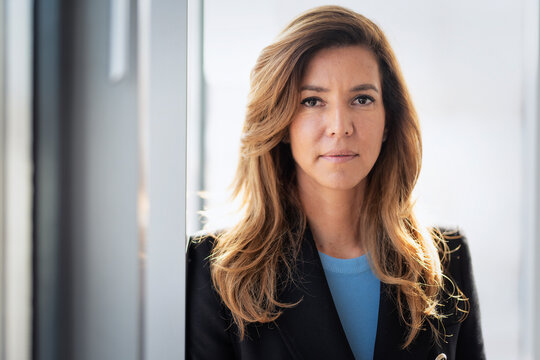 Portrait of an executive business woman standing by a window in a modern office