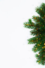 Elegant minimalistic composition with lush green natural fir tree branches and gold confetti on blank white flat lay background. For Christmas holiday designs, vertical post, seasonal greetings © Iryna Budanova