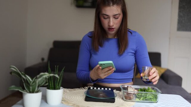 Healthy eating calorie counting meal planning Woman measures olive oil for balanced lunch while checking nutrition app to track calories and control daily intake