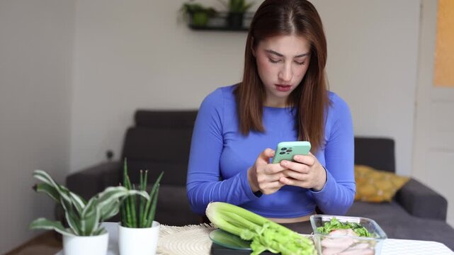 Calorie counting dominates an athlete daily routine as she tracks every meal on her phone preparing a pre weighed lunch box to stay within strict nutrition goals