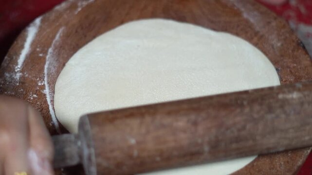 Indian Woman Hands Rolling Wheat Flour Dough for Large Roti or Paratha. Step by Step Process of Shaping Large Flatbread Dough with Wooden Belan.