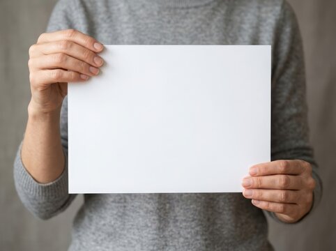 Person holding a blank piece of white paper in their hands