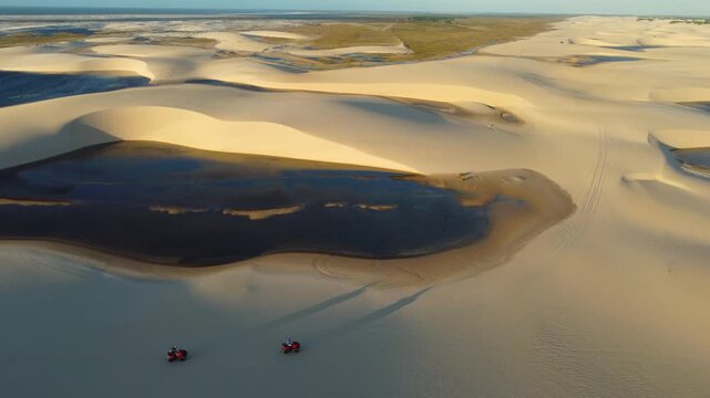 Distant quad bikes moving through Len&ccedil;&oacute;is Maranhenses landscape