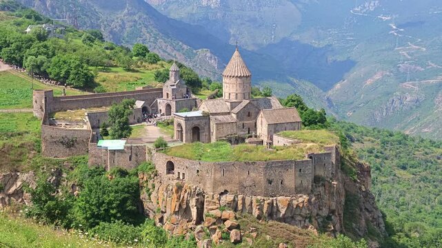 Ancient stone Tatev monastery perched high above lush green valley