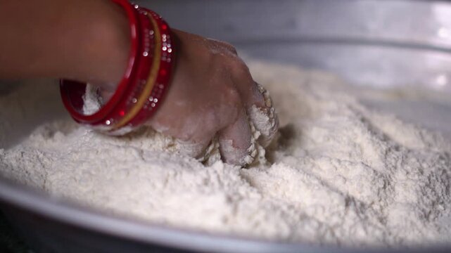 Traditional Indian Housewife Mixing Wheat Flour for Making Roti or Chapati. Traditional Homemaker Hand Mixing White Flour Powder for Baking in Indian Kitchen.