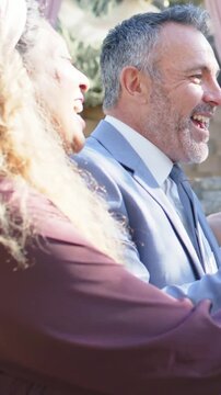 Vertical video: Groom leading toast bride in lace lifting glasses in garden toasting couple, flutes