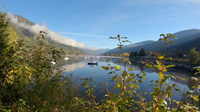 Kootenay Lake Mirror Reflection Morning Nelson BC 4K UHD. Boats anchored on Kootenay Lake in Nelson, British Columbia. The Big Orange Bridge crosses in the background. 4K UHD
