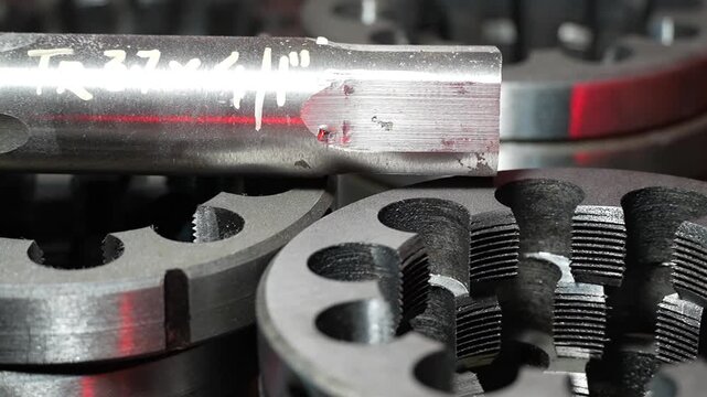 Close up of industrial threading dies and metal cutting tools in factory workshop. Detailed view of precision machining equipment used for engineering production and mechanical metalworking industry