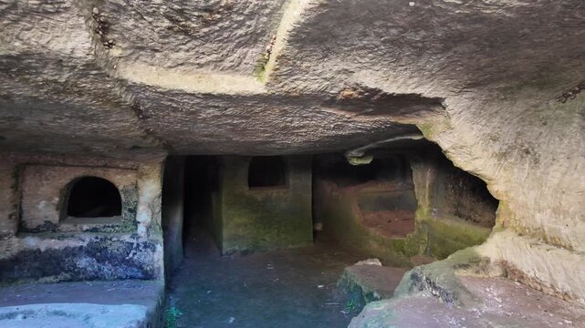 Salina, Malta 06.07.2026 - the interior of an ancient rock-cut catacomb reveals multiple carved burial niches and arched openings within a dimly lit stone chamber, showing centuries of natural weather