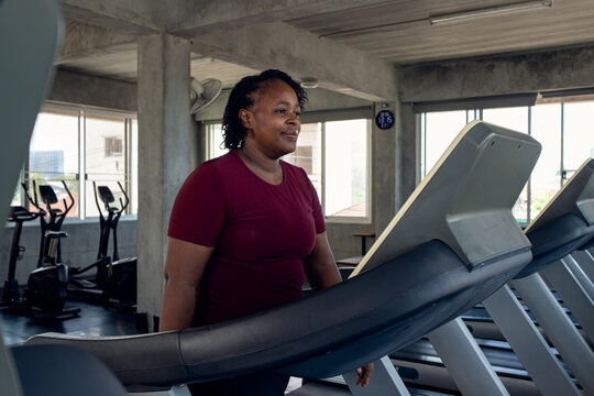 Woman exercising on a treadmill in a fitness gym, promoting cardio training, endurance, healthy living and wellness