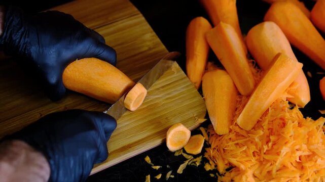 Fresh carrots sliced into round pieces on wooden cutting board with grated carrots nearby, healthy vegetables rich in vitamin A for soups, stews and homemade cooking