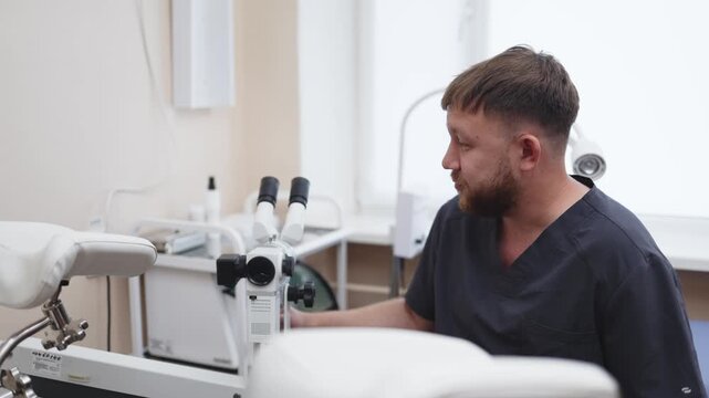 Gynecologist preparing a colposcope before a gynecological examination in a modern clinic. Concept women's health, gynecology, cervical diagnostics, preventive medicine, medical technology.