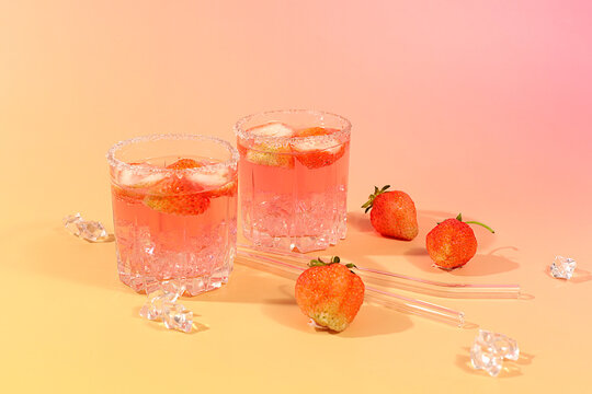 Modern still life with strawberry pink martini, layout, alcoholic cocktail with strawberries on an elegant modern background with long shadows, minimalist concept for bar and holiday party, cafe,