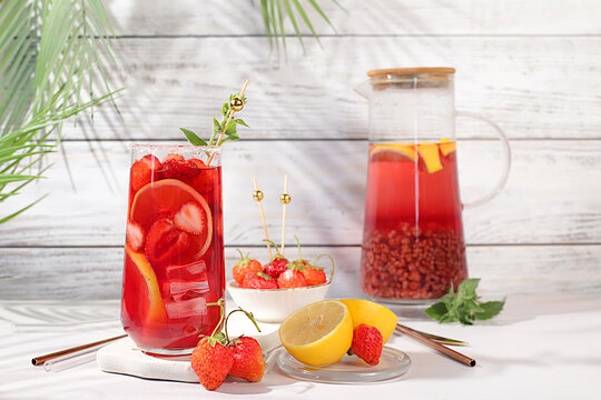 Refreshing summer homemade lemonade cocktail and non-alcoholic mojito, strawberry iced tea with berries, mint and lemon, weight loss concept, detox water with fruit flavor on light background.