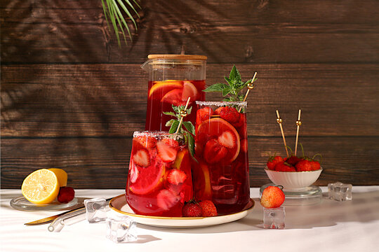 Refreshing summer homemade lemonade cocktail and non-alcoholic mojito, strawberry iced tea with berries, mint and lemon, weight loss concept, detox water with fruit flavor on light background.