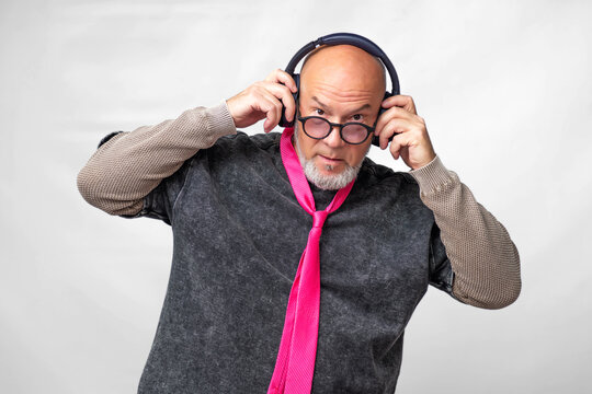 Emotional Senior Wearing Headphones Enjoying Music Against Colorful Studio Background