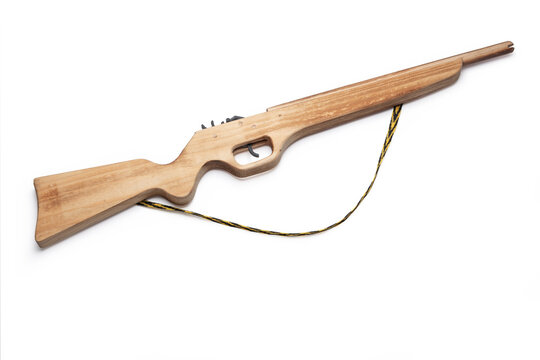 Handmade wooden toy rifle with a carrying strap isolated on white background