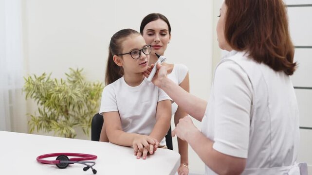 Mother accompanying her daughter during a pediatric appointment in a bright medical clinic. Concept pediatric medicine, child healthcare, family support, preventive medicine, wellness.