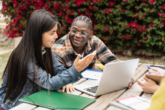 Two classmate students learning together with laptop preparing for exams and working on University project