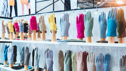 Display of gloves on mannequin stands shows different colors. Multiple hues line the shelf neatly. Each handwear style is presented clearly. Ideal for retail or fashion photography © Aleksandr Matveev