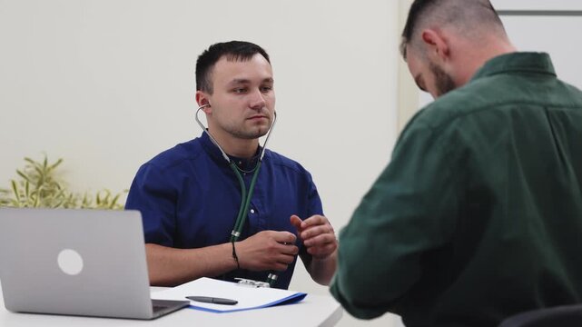 Family physician consulting a young man about his health in a modern medical clinic. Concept primary healthcare, medical consultation, patient care, preventive medicine, wellness.