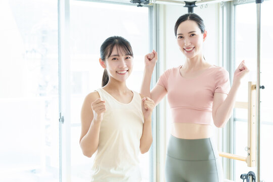 ピラティススタジオでガッツポーズをするインストラクターと生徒