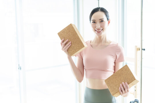 ヨガブロックを持つ女性　インストラクター