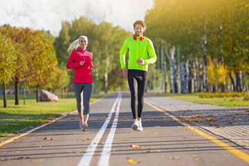 Fototapeta premium Running Couple Happily Jogging Together Outside as Runners Training Outdoors Working Out in City Outdoors.