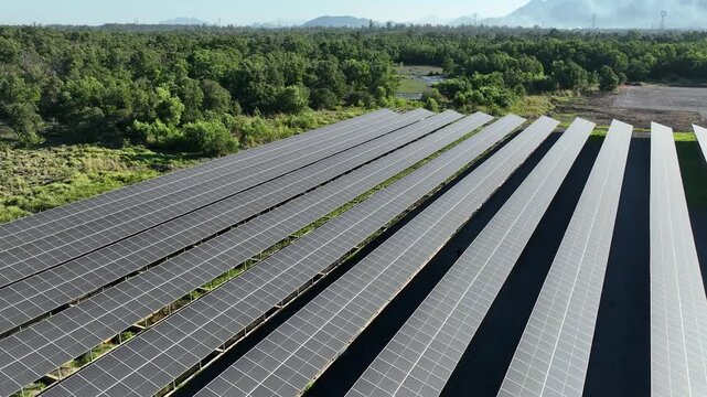 Aerial view of a solar panel and battery energy storage system. Clean, renewable solar energy. Located near a highway and cars, amidst an area of ​​greenery and farmland.