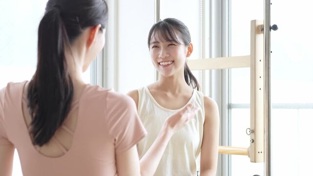 ピラティススタジオで話を聞く女性