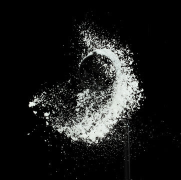 Fluffy White snow splash flying or throwing in mid air. Snowfall on Black background isolated. Snow dust element falling over dark night
