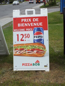 Gatineau,Quebec, Canada &ndash; May 27, 2026: This portable sandwich board sign advertises a petite poutine small poutine at "Pizza Bob" for take-out only au comptoir seulement on Chemin d'Aylmer.
