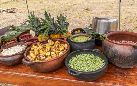 Preparation of Pachamanca, a traditional Andean underground cooking ritual in Ecuador. Fresh ingredients, potatoes, vegetables, chicken meat are arranged in clay bowls and then put to earth oven pit