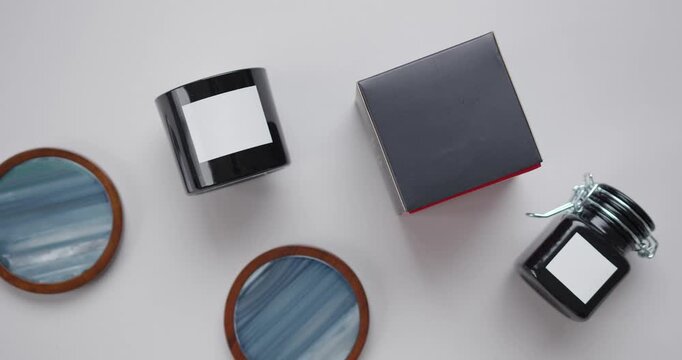 top view, candles, cup, black box, arrangement shot, overhead angle, flat lay, table setting, soft lighting, decorative scene, warm tones, minimal style, dark container, ceramic mug, wax candle, gift 