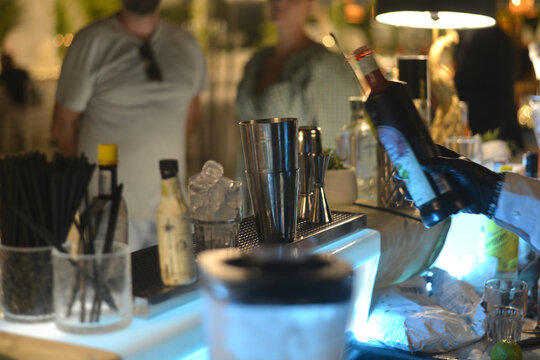 barman prepara un cocktail sul bancone di un bar all'aperto in estate