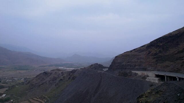 Swat Motorway follows a rocky mountainside above a broad valley at Zalam Kot, Khyber Pakhtunkhwa, Pakistan