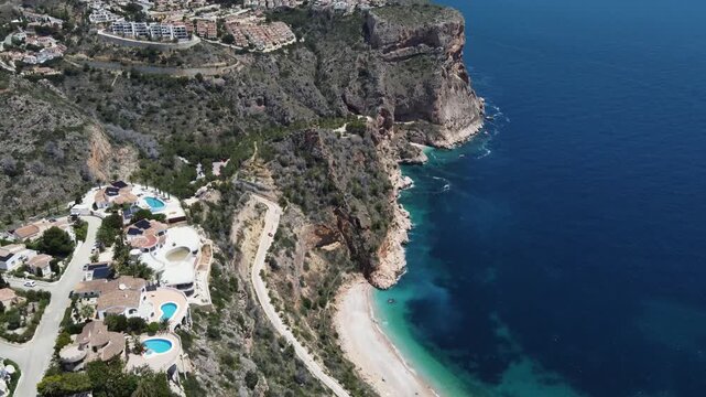 Aerial reveal of the Moraig cove and luxury villas in Benitachell, Spain.