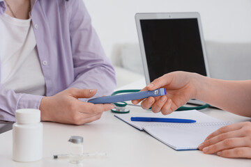 Fototapeta premium Female doctor giving hormone injection to patient at desk in clinic, closeup